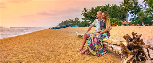 Mermaid Hotel & Club romantický pár sedí na pláži při západu slunce | Mermaid Hotel & Club