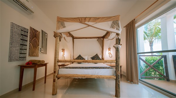 Manželská postel v pokoji typu Deluxe Standard. | Sansi Kendwa Beach Resort